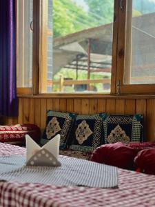 a room with two beds and a window at Alpine suites in Nagar