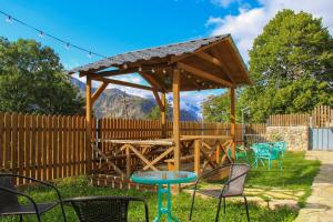 a wooden gazebo with chairs and a table at Hilltop Kazbegi in Kazbegi