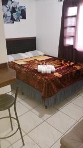 a bed in a room with a table and a chair at Hostel Maria Fumaça in Louro Müller