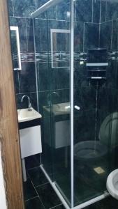 a bathroom with a glass shower and a sink at Hostel Maria Fumaça in Louro Müller