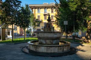 une fontaine au milieu d'une rue avec un bâtiment dans l'établissement BGY Maison del Borgo 1, à Bergame