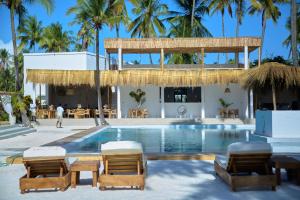 a resort with a swimming pool and chairs and palm trees at Mawimbi Zanzibar in Paje