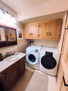 een kleine keuken met een wasmachine en een wastafel bij Moose Mountain Cabin- Cozy retreat with aurora views in Fairbanks
