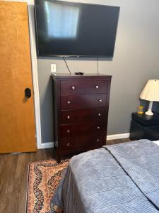 a bedroom with a dresser and a flat screen tv at Choice home in West Babylon