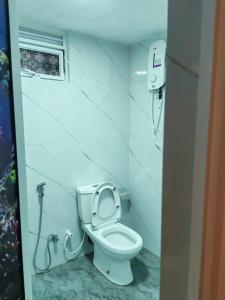 a bathroom with a white toilet in a room at Eco Bliss in Ahangama