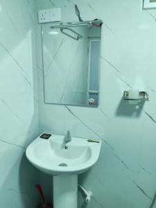 a white bathroom with a sink and a mirror at Eco Bliss in Ahangama