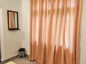 a orange curtain in a room with a mirror at Eco Bliss in Ahangama