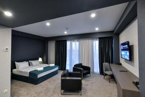 a bedroom with a bed and a tv and a desk at The West Inn-Georgia Hotel in Kutaisi