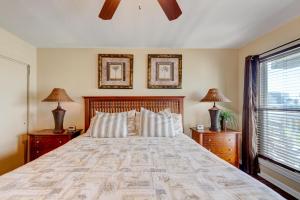 a bedroom with a large bed with two lamps and a window at Beach Bum Headquarters in Mustang Beach +38 photos