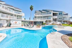 a swimming pool in front of a apartment building at Beach Bum Headquarters in Mustang Beach