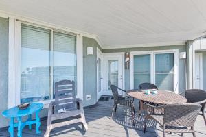 a patio with a table and chairs on a porch at Beach Bum Headquarters in Mustang Beach