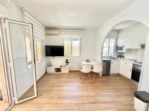 a kitchen with white cabinets and a table and chairs at Apartamento Caravaca in Santa Pola