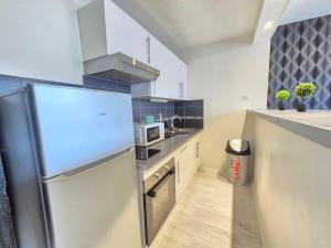 eine Küche mit Kühlschrank und Mikrowelle in der Unterkunft Le Berthelot #Parking in Clermont-Ferrand