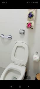 een badkamer met een wit toilet met bloemen aan de muur bij Casa de Calmaria in Cordeirópolis