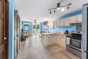 une cuisine avec des murs bleus et des armoires blanches dans l'établissement Puntas Rincon Villa 301 with private rooftop terrace, à Rincon