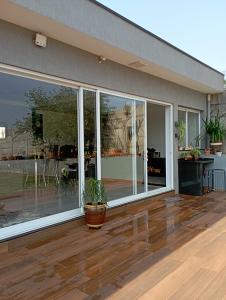 een huis met grote ramen en een potplant op een houten vloer bij Casa de Calmaria in Cordeirópolis