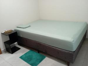 een bed in een kamer naast een tafel bij Casa de Calmaria in Cordeirópolis