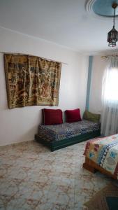 a room with two beds and a painting on the wall at Jalila House in Aourir