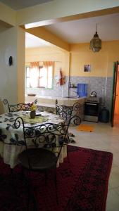 a kitchen with a table and chairs in a room at Jalila House in Aourir