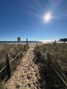 a person walking down a path on the beach at Aqua Amour Studio in Old Orchard Beach