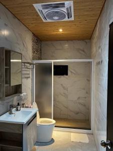 a bathroom with a shower and a toilet and a sink at 哈娜家Villa 