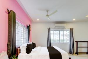 1 dormitorio con paredes de color rosa y blanco y 1 cama en Super Hotel O SRI NIRVANA PLAZA, en Gachibowli