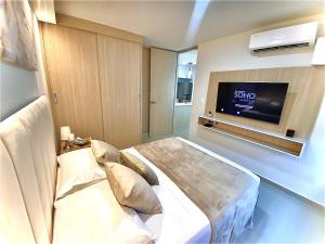 a hotel room with a bed and a flat screen tv at Mirador Apartments – Excellent Location by SOHO in Barranquilla