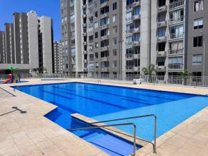 a large blue swimming pool with buildings in the background at Mirador Apartments – Excellent Location by SOHO in Barranquilla +59 photos
