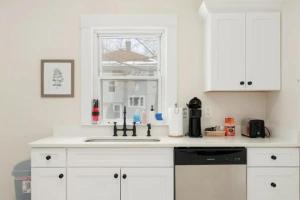 a white kitchen with a sink and a window at Sweet Retreat 3 Mins to Notre Dame Eddy St Commons and Memorial Hospital in South Bend