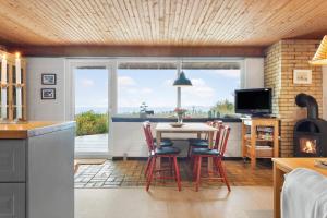 a kitchen with a table and chairs and a television at LF18112-Veslos-Jegindovej-12 in Amtoft