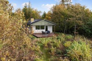 a small house with a deck in the woods at LF18112-Veslos-Jegindovej-12 in Amtoft
