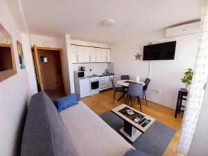 a living room with a couch and a table at Venus Apartman in Brčko