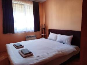 a bedroom with a bed with two towels on it at Venus Apartman in Brčko