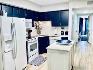 Una cocina con gabinetes azules y un refrigerador blanco. en Marina Maison 2BDR Condo, en Clear Lake Shores 26 fotos más