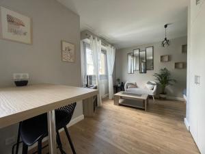 eine Küche und ein Wohnzimmer mit Tisch und Stühlen in der Unterkunft Le P’tit B - Quartier Saint-Michel/Centre Ville in Saint-Brieuc