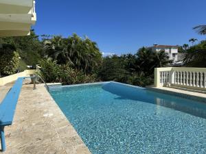 une piscine avec un banc à côté d'une maison dans l'établissement Puntas Rincon Villa 301 with private rooftop terrace, à Rincon 16 autres photos