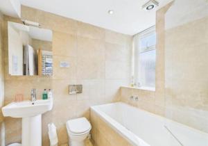 a bathroom with a tub and a toilet and a sink at Invergarry Room Only Guest House For Adults in Windermere +220 photos