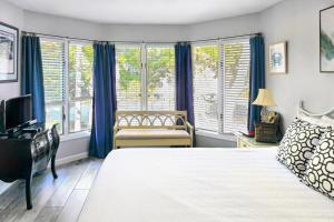 a bedroom with a bed and a desk and windows at TC5556: 5556 Turtle Cove in Kiawah Island