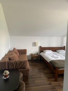 a room with two beds and a couch and a table at Vila Irina in Poiana Stampei