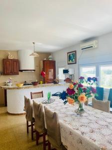 a kitchen with a table with flowers on it at Casa Joan de l'Illa in Deltebre