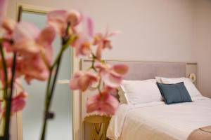 a bedroom with a bed with pink flowers and a mirror at Megaro Gioule in Siatista