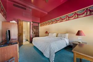Un dormitorio con una cama y un televisor de pantalla plana. en Historic Iron Horse Inn - Deadwood, en Deadwood