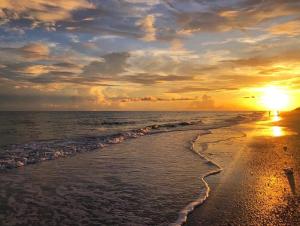 un tramonto su una spiaggia con l'oceano di White Sands #32 a Ybel