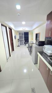 a large kitchen with white tile flooring in a room at Burnham Hill 504 Baguio Condo by Dei Gratia in Baguio