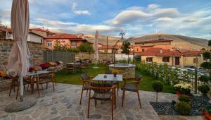 a patio with tables and chairs in a yard at Megaro Gioule in Siatista +19 photos