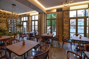 a restaurant with tables and chairs and windows at Megaro Gioule in Siátista