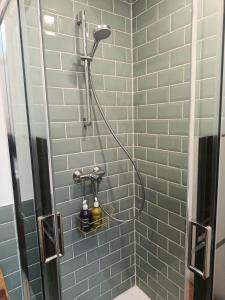 a shower in a bathroom with blue tiles at Secteur digue Dunkerque, Escale a Malo, Aquae Mare in Dunkerque +18 photos