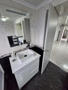 a white bathroom with a sink and a mirror at Alma Atlântica - Pure Nature & Beach in Praia do Almoxarife +13 photos