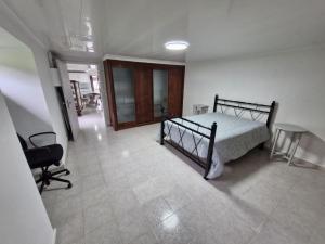 a bedroom with a bed and a desk and a chair at Alma Atlântica - Pure Nature & Beach in Praia do Almoxarife