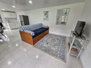 a living room with a blue couch and a television at Alma Atlântica - Pure Nature & Beach in Praia do Almoxarife